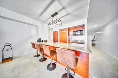 a kitchen with a long wooden table and chairs at South City Suites in Hallandale Beach