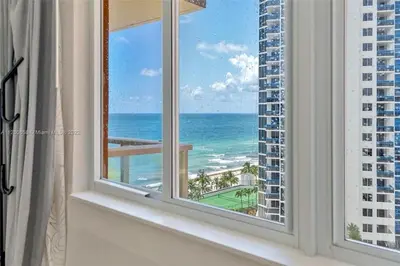 a room with a window with a view of the ocean at Lujoso Departamento Con VIstas Al Mar- Miami Beach in Sunny Isles Beach