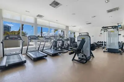 a gym with a bunch of treadms and cardio machines at Champagne at Tiffany's - Luxury Condo by the Beach in Fort Lauderdale