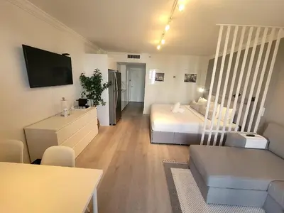 a bedroom with a bed and a living room at Estudios en las playa de Sunny Isles Beach in Sunny Isles Beach
