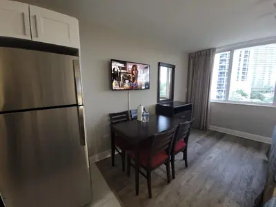 a kitchen with a dining room table and a refrigerator at Estudios en las playa de Sunny Isles Beach in Sunny Isles Beach