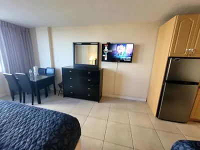 a hotel room with a television and a dining table at Estudios en las playa de Sunny Isles Beach in Sunny Isles Beach