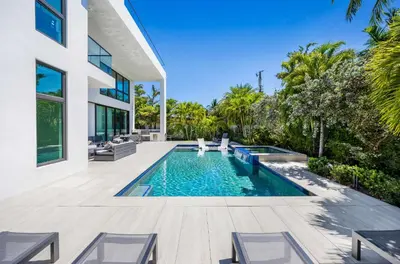 a swimming pool in the backyard of a house at LVS Villa Blanco 5BR Coastal Oasis with Rooftop Sunset Deck Heated Pool Spa & Walk-to-Beach Access in Fort Lauderdale