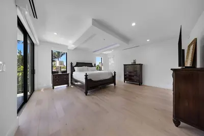 a large white bedroom with a bed and a dresser at LVS Villa Blanco 5BR Coastal Oasis with Rooftop Sunset Deck Heated Pool Spa & Walk-to-Beach Access in Fort Lauderdale