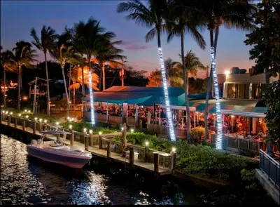 a boat is docked next to a dock with lights at 2 Br 2 Bath Waterfront Apt Walking To Beach in Hallandale Beach