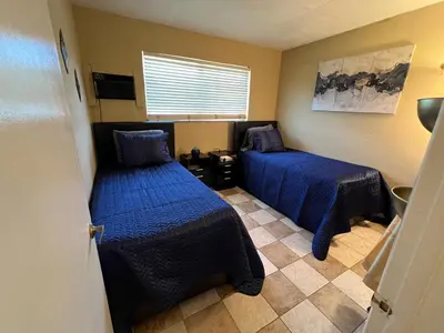 a small room with two beds and a window at Lovely 2 Bedroom Condo With Free Parking & Wifi!! in Sunrise
