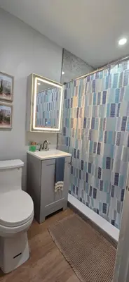 a bathroom with a toilet and a sink and a mirror at Aquamarina in Fort Lauderdale