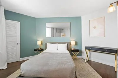 a bedroom with a bed and a mirror on the wall at SUNNY ISLES 4BR Pool & Beach Access in Sunny Isles Beach