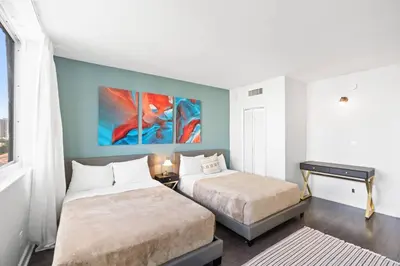 a bedroom with two beds and a desk in it at SUNNY ISLES 4BR Pool & Beach Access in Sunny Isles Beach