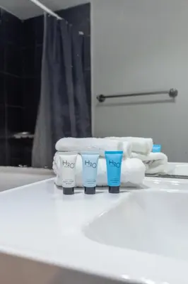 a bathroom sink with two cups and towels on it at UNIT #1108 Castle Beach Club Condominium in Miami Beach