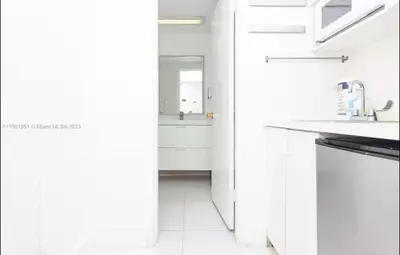 a white kitchen with a sink and a refrigerator at UNIT #1108 Castle Beach Club Condominium in Miami Beach