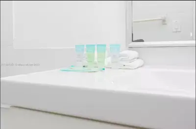 a bathroom counter with a mirror and a sink at UNIT #1108 Castle Beach Club Condominium in Miami Beach