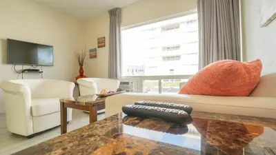 a living room with a couch and a tv at Soleado Hotel in Fort Lauderdale