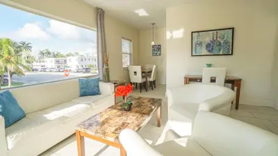 a living room with white furniture and a large window at Soleado Hotel in Fort Lauderdale