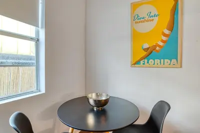 a table and chairs in a room with a sign at So South Beach in Miami Beach