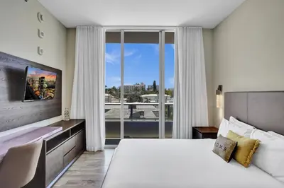 a bedroom with a large bed and a large window at New Luxury Beachfront Condo with Rooftop Pool in Hollywood