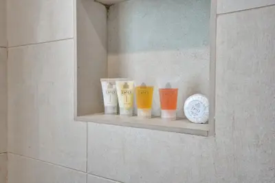 a shelf in a bathroom with four cups on it at New Luxury Beachfront Condo with Rooftop Pool in Hollywood