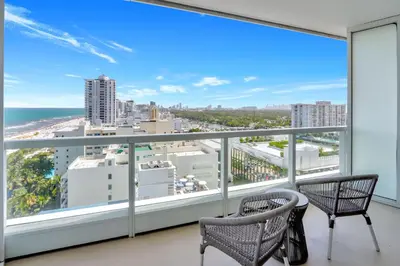a balcony with two chairs and a view of the ocean at Luxury Oceanview Suite at the Fontainebleau Miami Beach with Balcony, King & Sofa Bed in Miami Beach