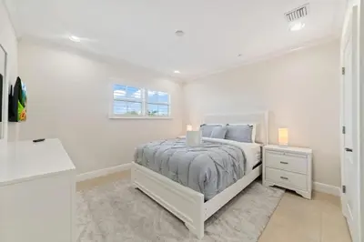 a white bedroom with a bed and a window at Lux Home with Rooftop & Elevator 2mi to Beach in Fort Lauderdale