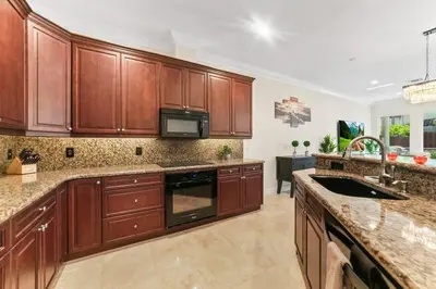 a large kitchen with wooden cabinets and a sink at Lux Home with Rooftop & Elevator 2mi to Beach in Fort Lauderdale