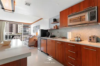 a kitchen with wooden cabinets and a microwave at Spectacular 1-Bedroom Apartment Beach view in Miami Beach