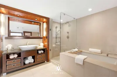 a bathroom with a sink and a tub and a mirror at Spectacular 1-Bedroom Apartment Beach view in Miami Beach