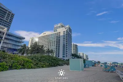 a beach with some chairs and some buildings at Spectacular 1-Bedroom Apartment Beach view in Miami Beach