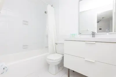 a white bathroom with a toilet and a sink at UNIT #908 Castle Beach Club Condominium in Miami Beach