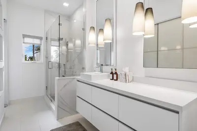 a white bathroom with two sinks and a shower at Riviera Reserve by Stay Awhile Villas in Fort Lauderdale