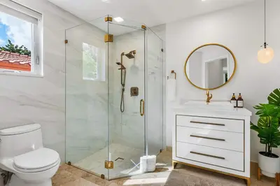 a bathroom with a shower and a toilet and a mirror at Riviera Reserve by Stay Awhile Villas in Fort Lauderdale