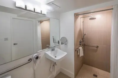 a bathroom with a sink and a shower at President Hotel Villa in Miami Beach