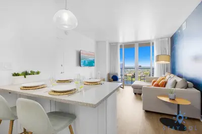 a kitchen and living room with a table and a couch at Stylish 2BR High-Rise Retreat w Ocean Views in Hallandale Beach