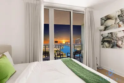 a bedroom with a bed and a view of the city at Stylish 2BR High-Rise Retreat w Ocean Views in Hallandale Beach