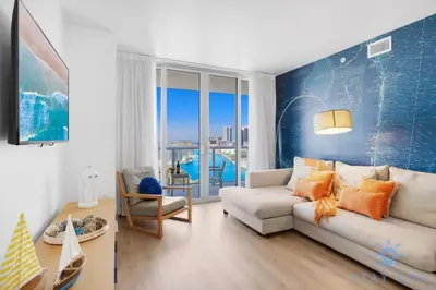 a living room with a white couch and a blue wall at Stylish 2BR High-Rise Retreat w Ocean Views in Hallandale Beach
