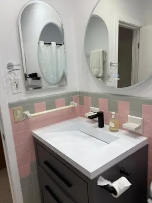 a bathroom with a sink and two mirrors at Mid-Century with Outdoor Oasis in Fort Lauderdale