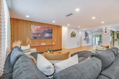 a living room with a large gray couch at Fox Garden Luxury Boho Near Downtown & Beach home in Fort Lauderdale