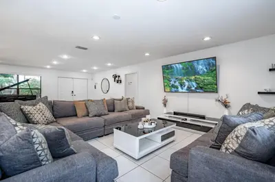 a living room with two couches and a flat screen tv at Fox Island Heated Spa- Downtown & Beach home in Fort Lauderdale