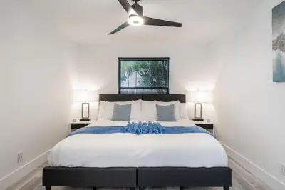 a bedroom with a large bed with a ceiling fan at Fox Island Heated Spa- Downtown & Beach home in Fort Lauderdale
