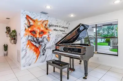 a piano in a room with a painting of a fox at Fox Island Heated Spa- Downtown & Beach home in Fort Lauderdale