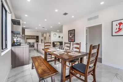 a kitchen and dining room with a wooden table and chairs at Fox Sonata Downtown Pool House home in Fort Lauderdale