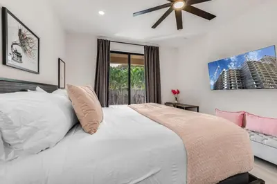a bedroom with a white bed with a ceiling fan at Fox Sonata Downtown Pool House home in Fort Lauderdale