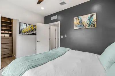 a bedroom with a large white bed with two pictures on the wall at Fox Sonata Downtown Pool House home in Fort Lauderdale