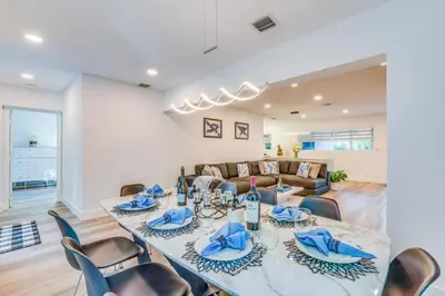 a dining room with a long table and chairs at Friendly Fox Luxury Pool & Spa - Near DT & Beach home in Fort Lauderdale