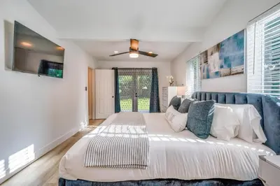 a bedroom with a large bed with a blue couch at Friendly Fox Luxury Pool & Spa - Near DT & Beach home in Fort Lauderdale