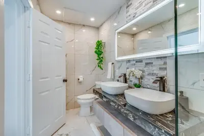a bathroom with two sinks and a toilet at Friendly Fox Luxury Pool & Spa - Near DT & Beach home in Fort Lauderdale