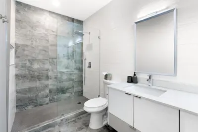 a white bathroom with a toilet and a shower at Golden Fox Downtown Pool House home in Fort Lauderdale
