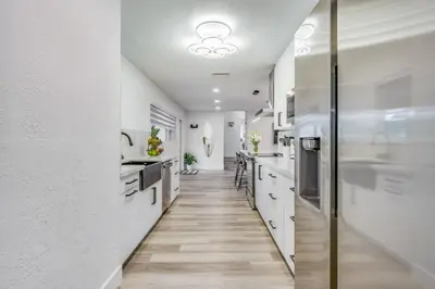 a kitchen with white walls and a long hallway at Fox Private Resort- Near Downtown & Beach home in Fort Lauderdale