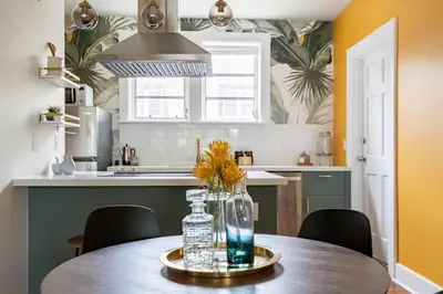 a kitchen with a table with a vase of flowers on it at Designer 2br, king-size bed, 5mins to the beach J1 in Hollywood