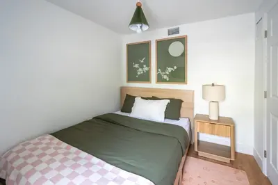 a small bedroom with a bed and a lamp at Designer Gem Condo - 5 Mins to Sand, Playground, Tennis, Free Parking in Hollywood