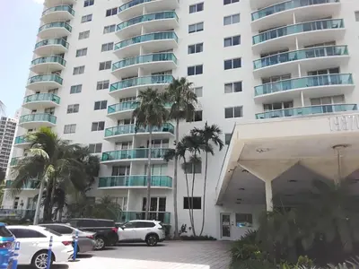 a parking lot in front of a large apartment building at Ocean reserve 2 bedroom plus den in Sunny Isles Beach